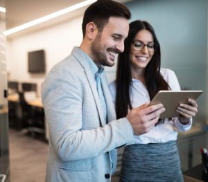 Business partners looking at the tablet while walking inside the office