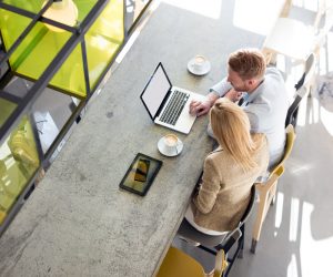 Man and woman in a restaurant working together using a laptop